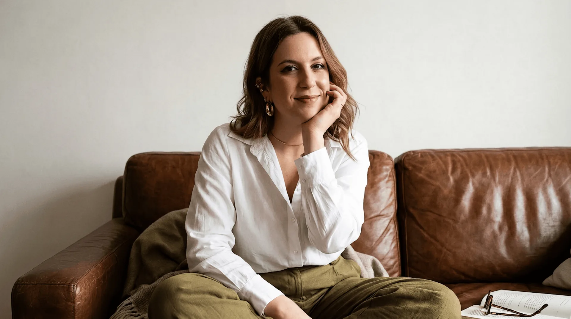 Rafaela Coltro sentada no sofá, olhando para a câmera